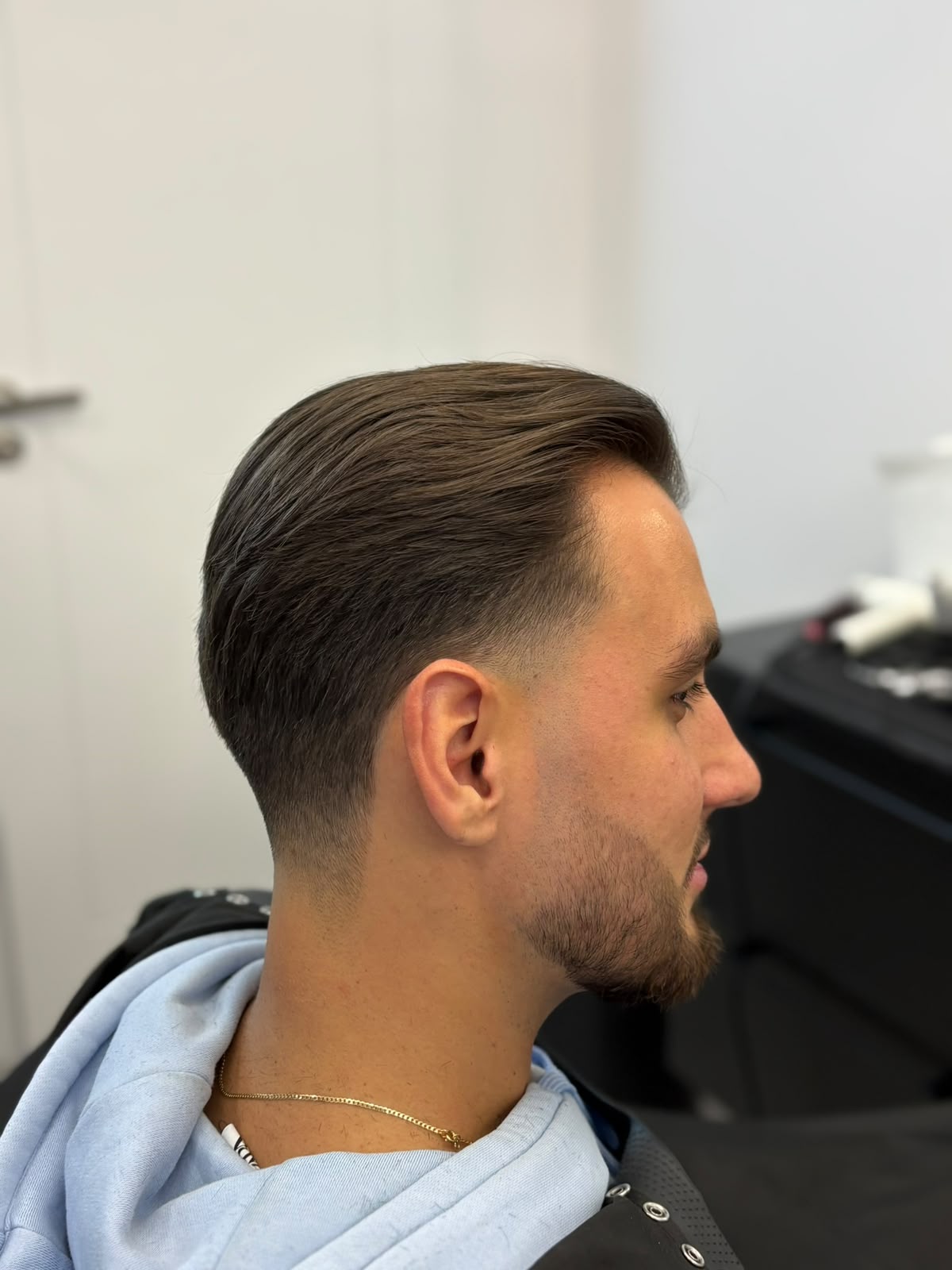 Niski fade z zaczesaniem na bok i konturem brody - Handmade Barbershop Warszawa Mokotów